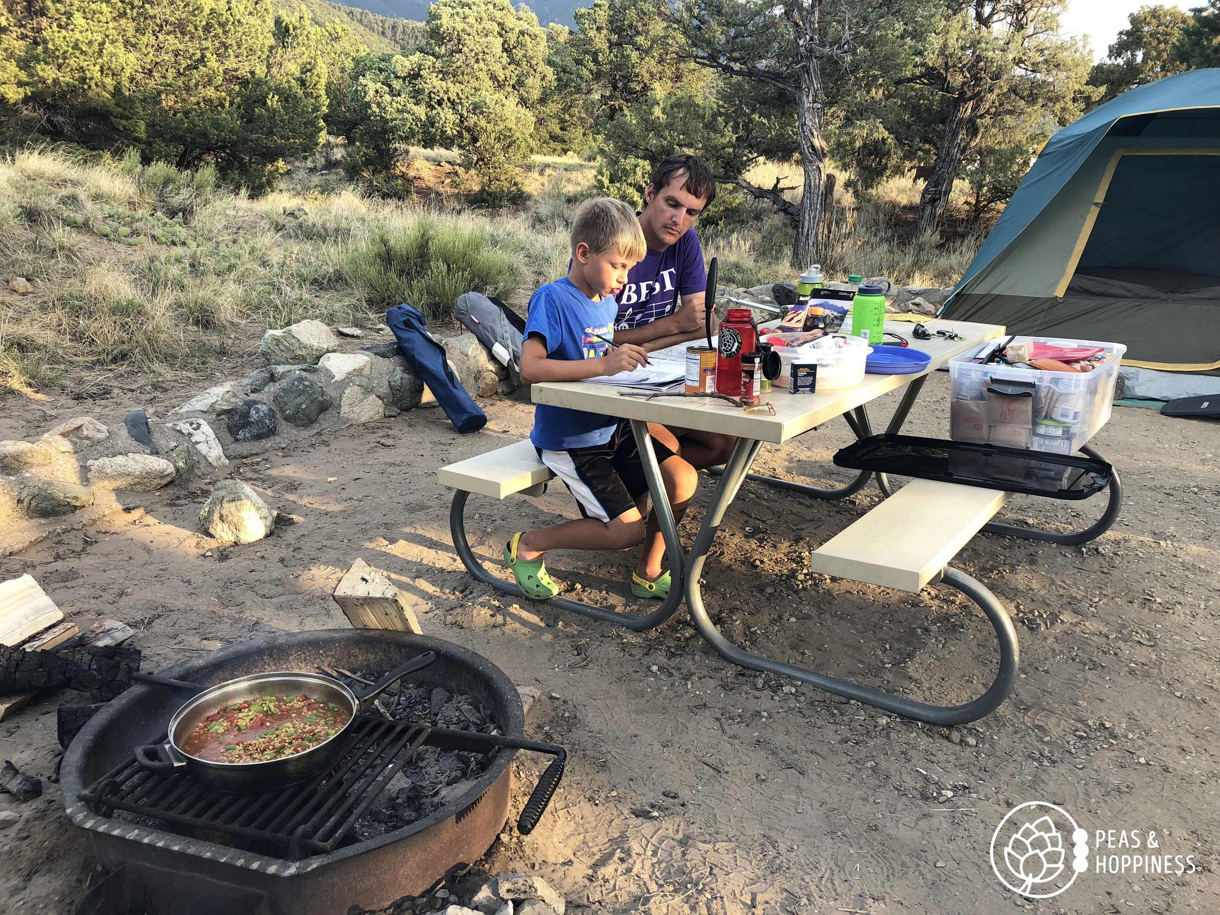 Working on Jonah's Junior Ranger book while Lentil Frito Pie cooks over the fire. Great Sand Dunes National Park.
