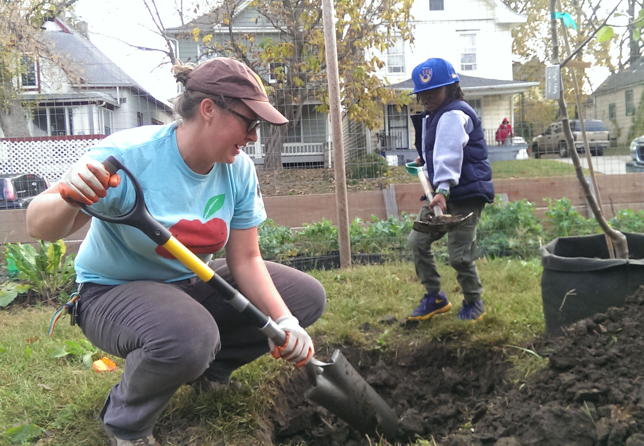 Amanda working on a planting project with a neighborhood kiddo