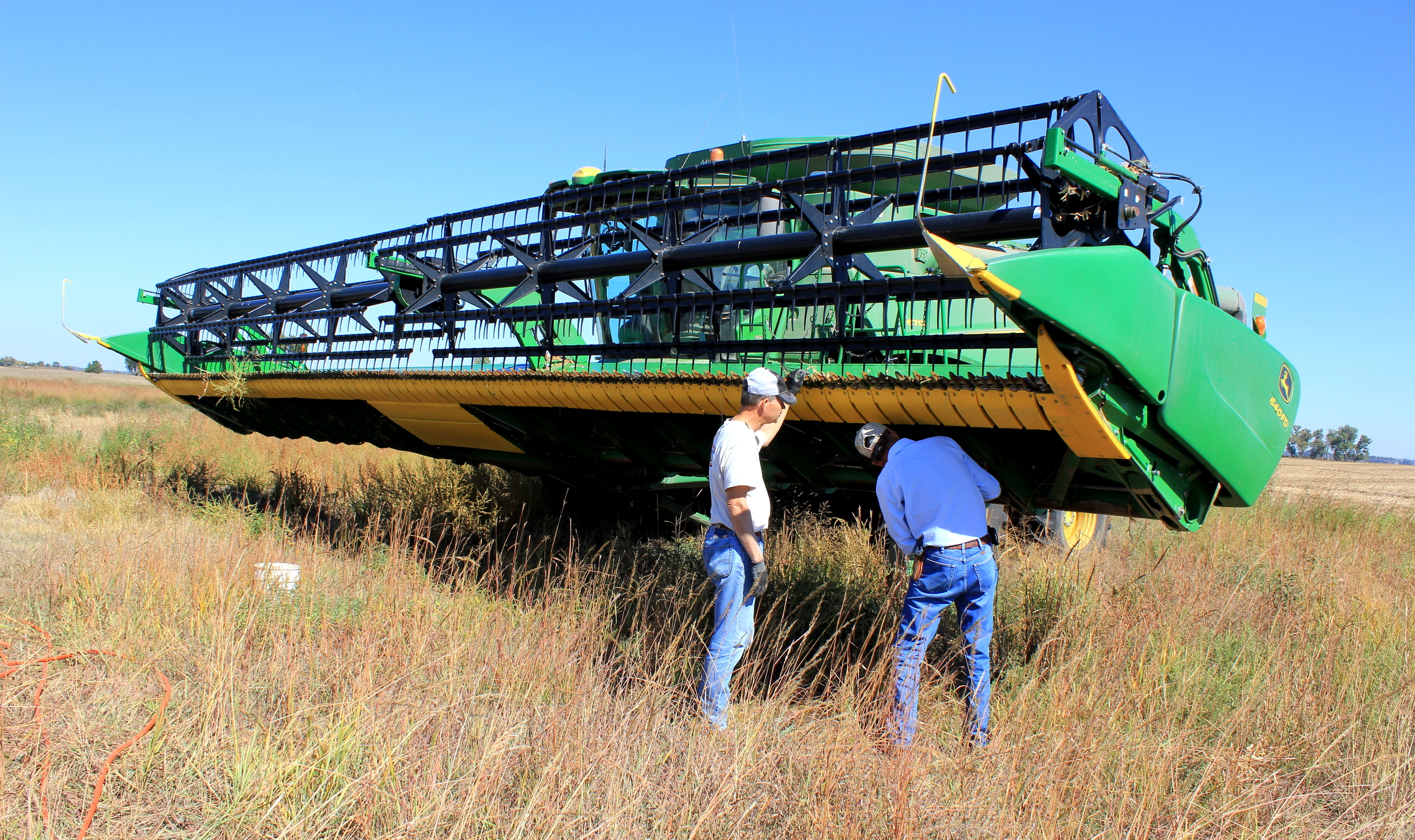 Dad and Vince adjusting the header of the combine to harvest milo