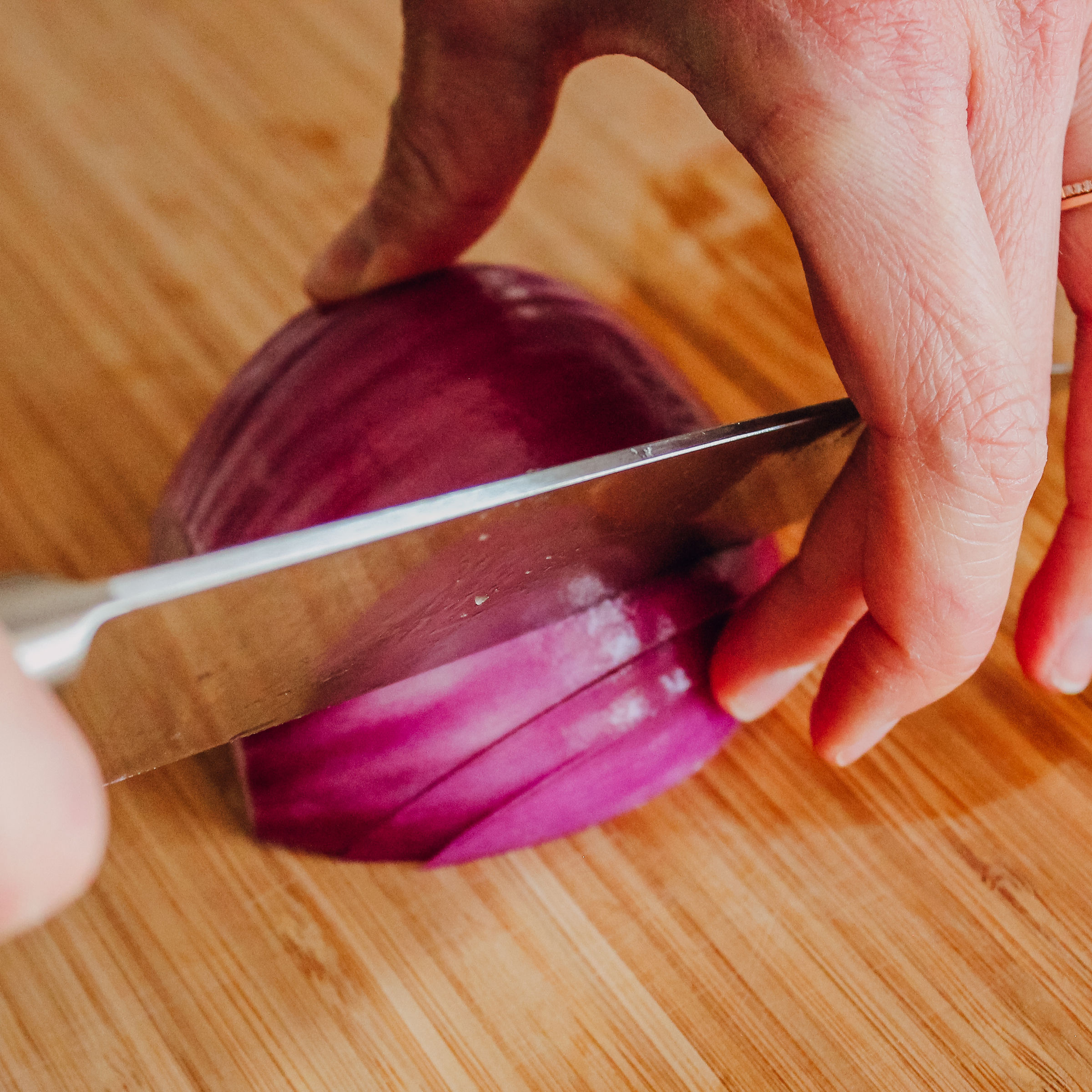Close up of slicing onion with a chef's knife
