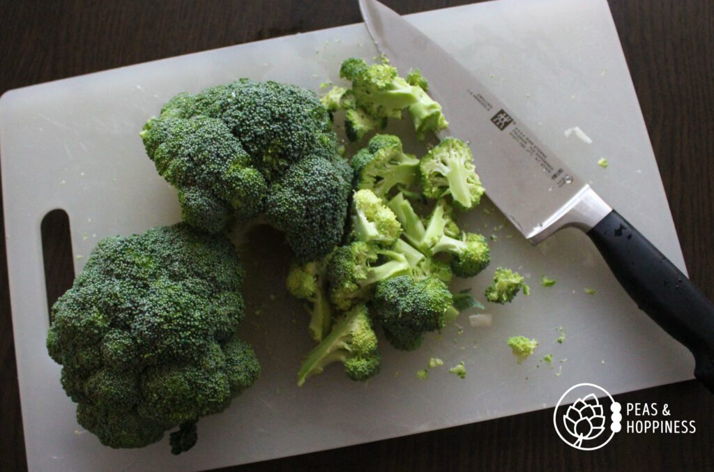 Broccoli and florets on a cutting board with chef's knife