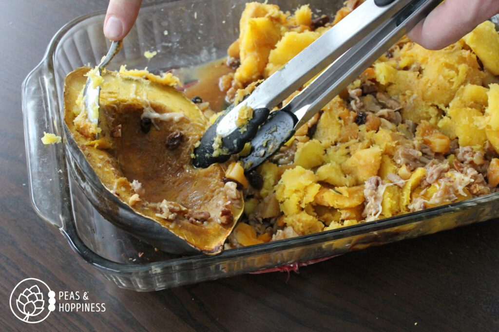 Scooping cooked acorn squash flesh out of shell